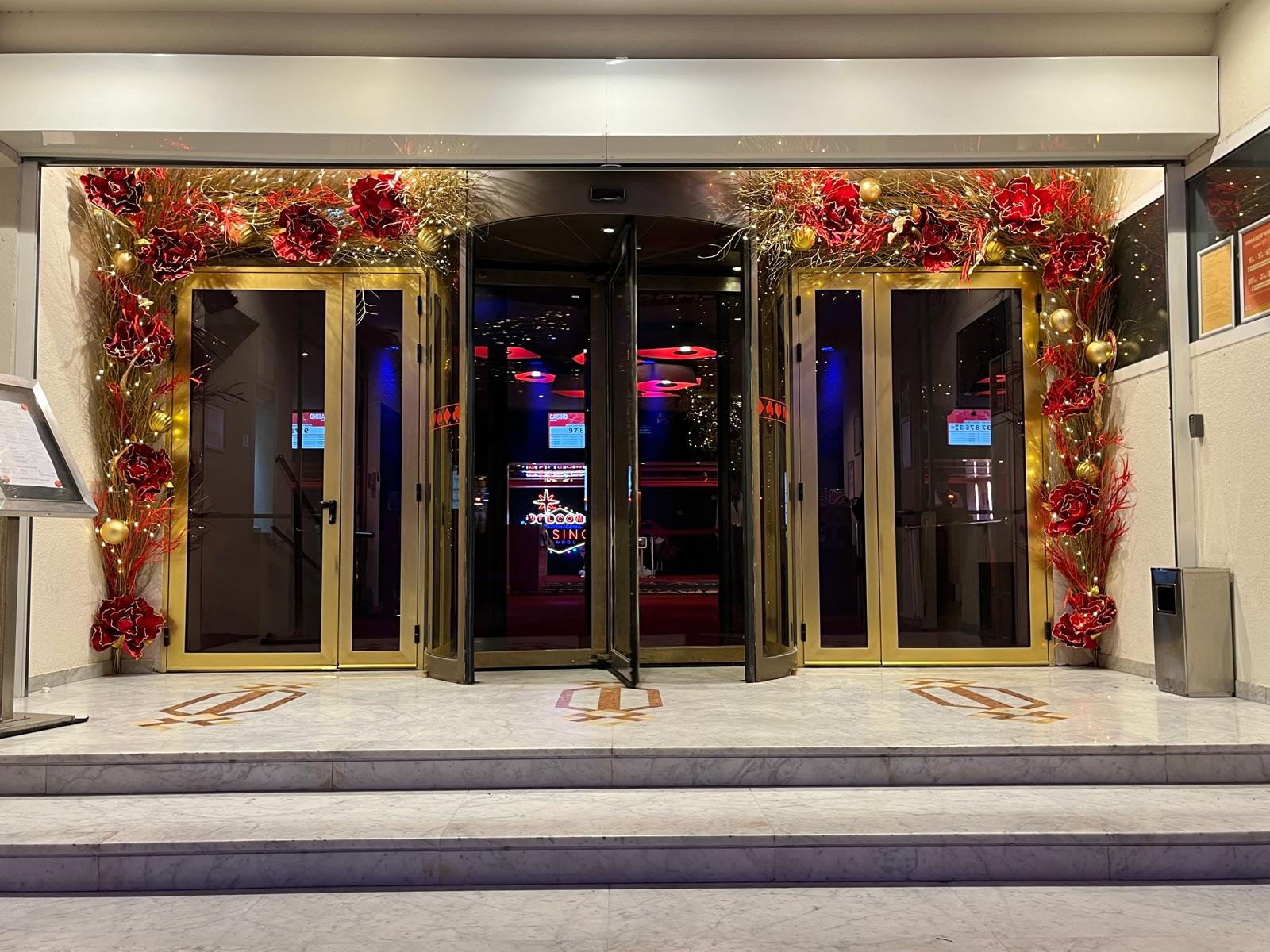 Entrée principale du Casino Partouche Bandol encadrée de fleurs rouges et dorées pour Noël