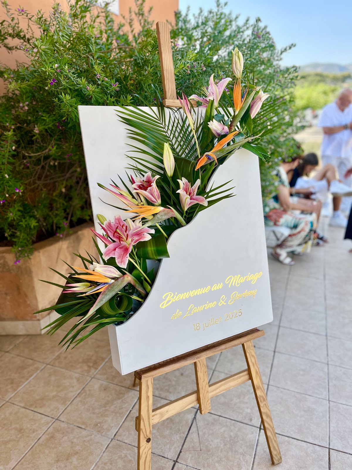 Panneau de bienvenue de mariage décoré de lys roses et oiseaux de paradis exotiques