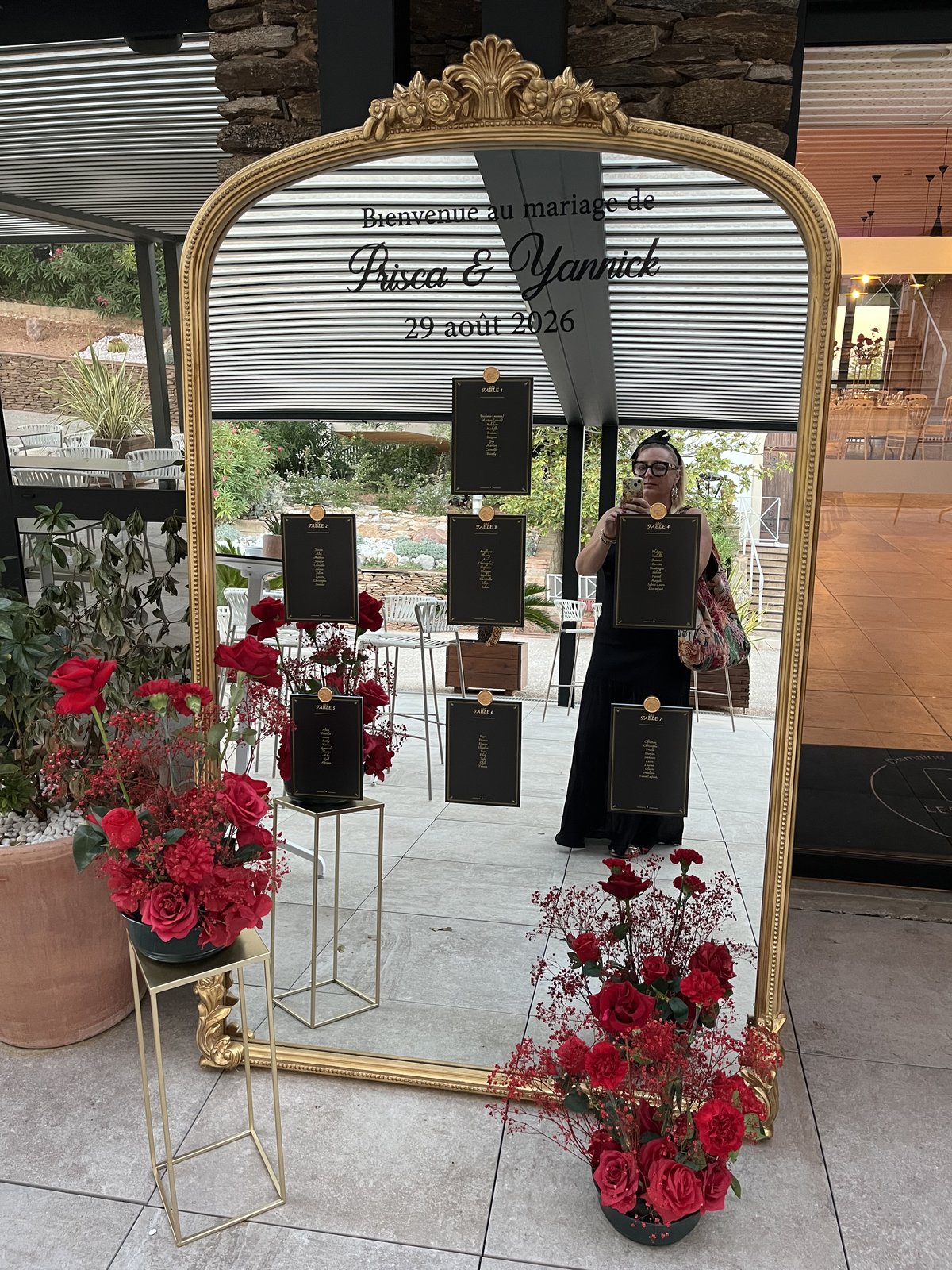 Miroir doré de bienvenue pour le mariage de Prisca et Yannick entouré de roses rouges