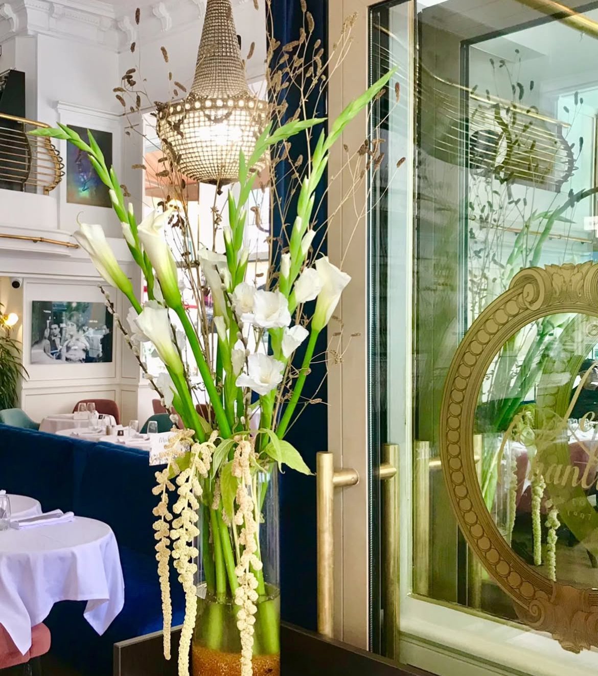 Bouquet de glaïeuls et arums blancs avec amarantes dans un vase en verre, restaurant Le Chantilly